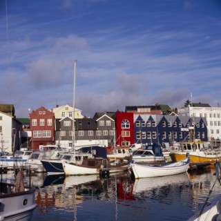 DENMARK, Faroe Islands, Torshavn, Boats moored in harbour with colourful waterfront buildings