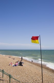 ENGLAND, East Sussex, Brighton, Life guard flag on the beach at Hove.