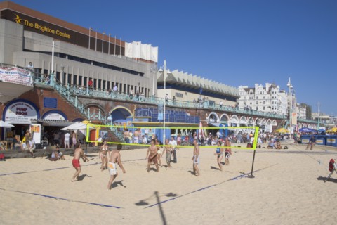 ENGLAND, East Sussex, Brighton, People playing beach volleybal on the sands in front of the