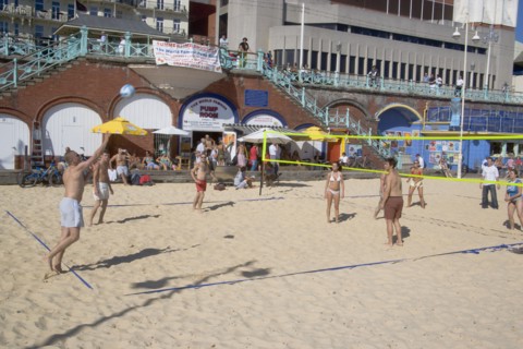 ENGLAND, East Sussex, Brighton, People playing beach volleybal on the sands in front of the