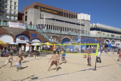 ENGLAND, East Sussex, Brighton, People playing beach volleybal on the sands in front of the