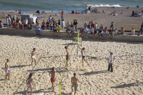 ENGLAND, East Sussex, Brighton, Beach volleyball game on the sands in front of the Grand Hotel.