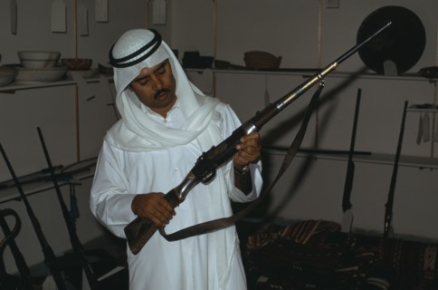 QATAR, Doha, Man holding an old rifle in Doha Museum