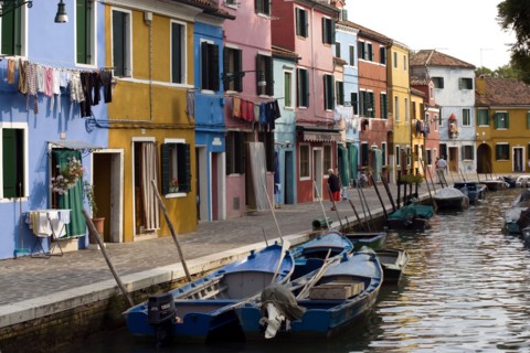 ITALY, Veneto, Venice, Colourful houses beside a canal on the lagoon island of Burano with tourists