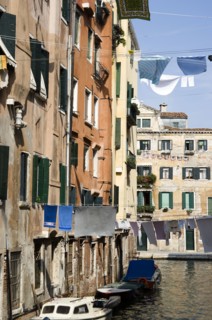 ITALY, Veneto, Venice, Washing hanging from lines above a canal from buildings in the Ghetto. The