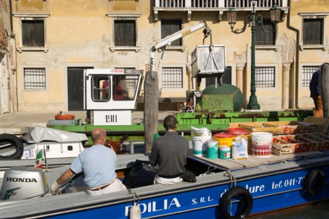 ITALY, Veneto, Venice, Painters and decorators wait to moor their boat on the Grand Canal whilst a