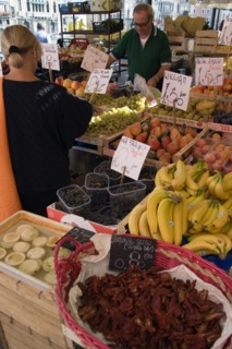 ITALY, Veneto, Venice, Fruit and vegetable stall in the Rialto market with shopper and vendor