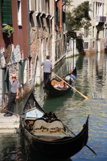 ITALY, Veneto, Venice, A Gondola with tourists passing along a canal in the San Marco district.