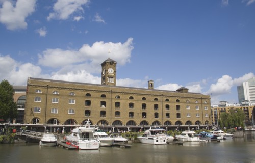 ENGLAND, London, St Catherine’s Dock with yachts moored next to the former warehouses which are now