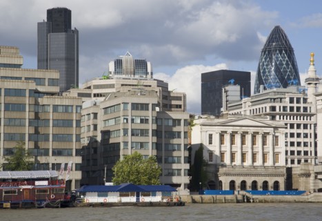 ENGLAND, London, "The Gherkin Swiss Re building seen, through tightly huddled buildings in the