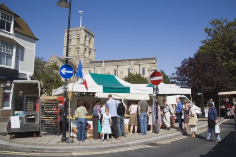 ENGLAND, West Sussex, Shoreham-by-Sea, French Market. People gathered around covered market stalls
