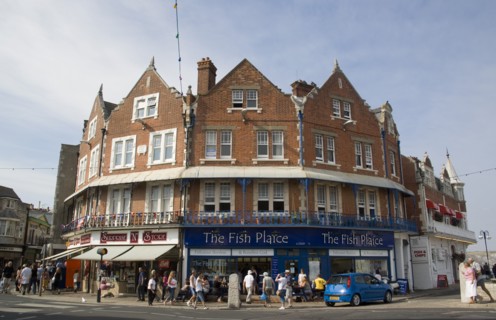 ENGLAND, Dorset, Swanage, Shop fronts in the town centre with The Fish Plaice Fish and Chip shop.