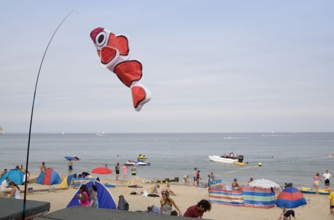 ENGLAND, Dorset, Swanage Bay, Busy colourful sandy beach with sunbathers on the sand and speedboats