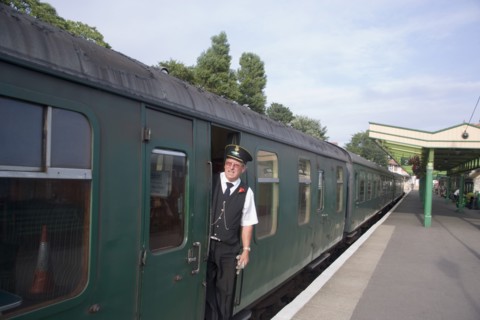 ENGLAND, Dorset, Swanage, Steam Railway Station. View along platform with train departing from