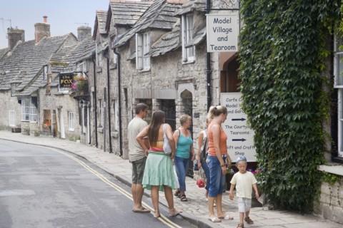 ENGLAND, Dorset, Corfe, Visitors outside a Model Village and Tearoom shop in a row of traditional