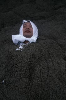 JAPAN, Kyushu, Ibusuki, Sunabulo. Hot Sand Bath with a man wearing a white towel wrapped around his