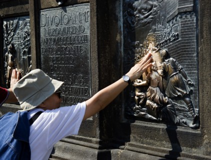 CZECH REPUBLIC, Bohemia, Prague, Tourist touching for luck the relief of the martyrdom of St John