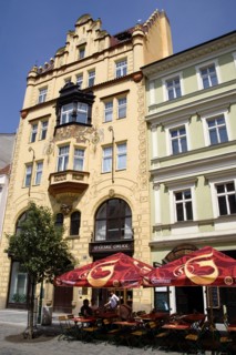 CZECH REPUBLIC, Bohemia, Prague, "Old Town. Tourists sitting at tables under umbrellas outside a