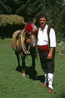 BULGARIA, Chalin Valog, "Man in national costume standing with horse. Pirin Mountain, near Bansko,.
