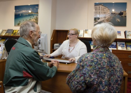 ENGLAND, West Sussex, Chichester, Male and female customer in a Travel Agents office discussing
