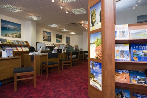 ENGLAND, West Sussex, Chichester, Male and female customer in a Travel Agents office discussing