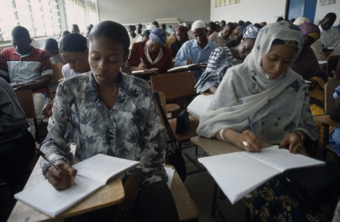 NIGERIA, Kano, Students writing at desks in law school.