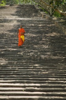 SRI LANKA, Mihintale, "A lone monk descending The Stairway, 1840 granite steps that lead up to the