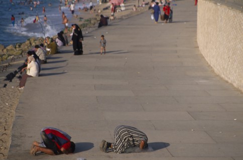EGYPT, Nile Delta, Alexandria, Corniche Waterfront . People sitting on the edge of the promenade