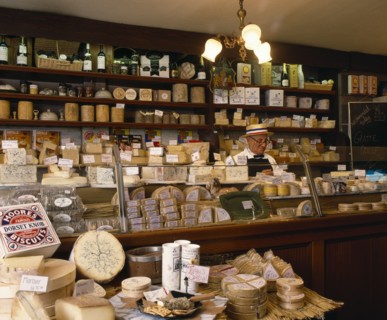 FOOD, Cheese, Man behind counter of specialist cheese delicatessen