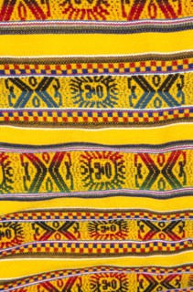 PERU, near Machu Picchu, Aguas Calientes, Colourful woven blanket in market.