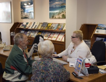 ENGLAND, West Sussex, Chichester, Male and female customer in a Travel Agents office discussing