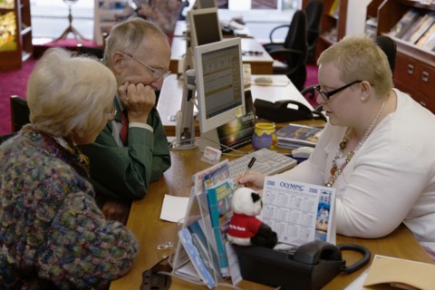 ENGLAND, West Sussex, Chichester, Male and female customer in a Travel Agents office discussing