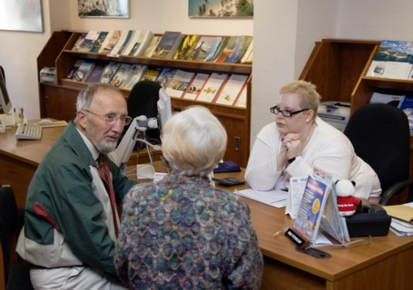 ENGLAND, West Sussex, Chichester, Male and female customer in a Travel Agents office discussing