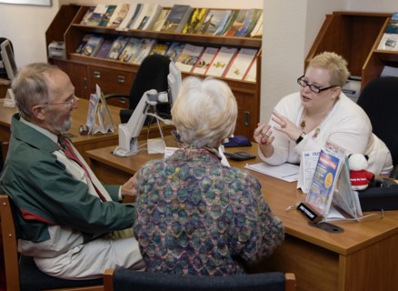ENGLAND, West Sussex, Chichester, Male and female customer in a Travel Agents office discussing