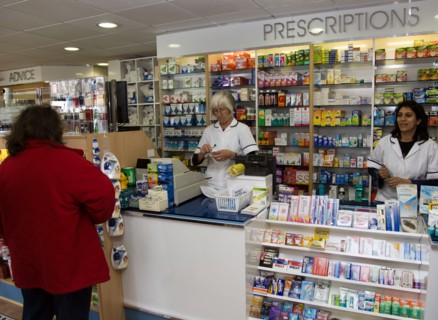 ENGLAND, East Sussex, Shoreham by sea, Interior of high street dispensing chemist  with female