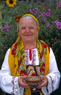 BULGARIA, Dobarsko, "Dobarski Babi Folk Group, member of folk group holding bowl of salt."