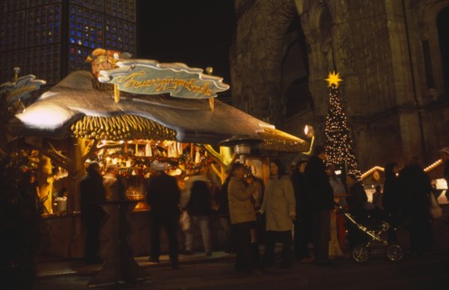 GERMANY, Berlin, "Breitscheidplatz. Christmas Market. People gathered around an Illuminated stall