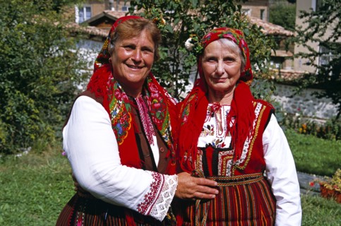 BULGARIA, Dobarsko, "Member of Dobarski Babi Folk Group, and tourist on right, in national costume"