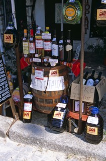BULGARIA, Melnik., "Display of wine bottles, barrel, and containers outside shop."
