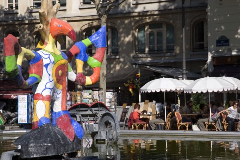 FRANCE, Ile de France, Paris, People sitting at tables under umbrellas beside the colourful