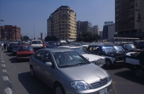 EGYPT, Cairo Area, Cairo, Busy road with traffic and tall buildings behind
