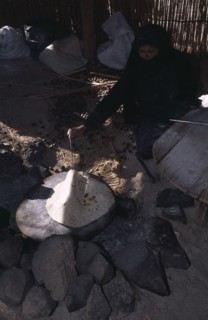 EGYPT, Eastern Desert, Bedouin woman cooking Chapatti