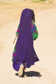 AFGHANISTAN, between Chakhcharan and Jam, Desert, Kuchie nomad girl walking behind camel train