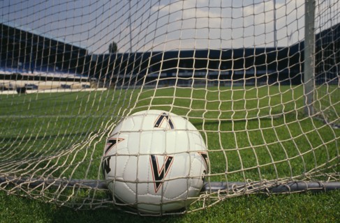 20085445 SPORT Ball Games Football Close shot of football in back of net of goal on soccer pitch.