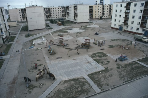 MONGOLIA, Baga Noor, Multi storey housing in coal mining town surrounding playground with children