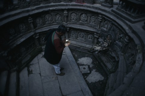 NEPAL, Kathmandu, "Man worshipping in sunken tank and former royal bath known as Tusha Hiti in