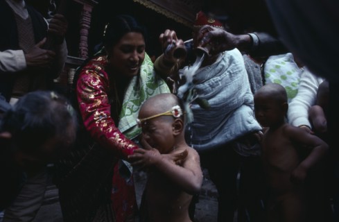 20085633 NEPAL  Patan Buddhist priests and family bless young boy with milk during his bhartavan or manhood ceremony.