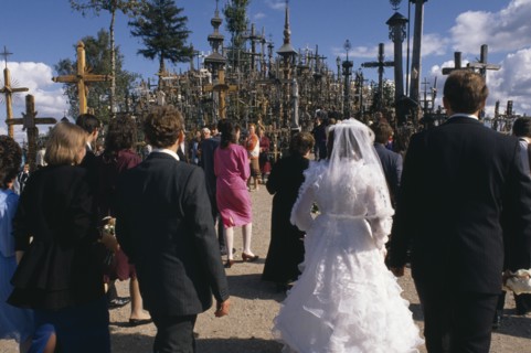 LITHUANIA, Hill of Crosses, Wedding group in front of hundreds of crosses and crucifix at ancient