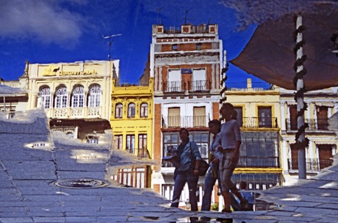 SPAIN, Andalucia, Seville, Reflection of buildings and pedestrians in Plaza de San Francisco.