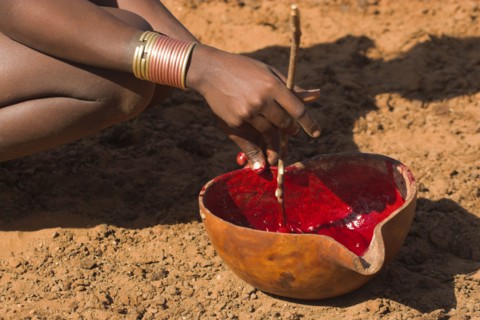 ETHIOPIA, Lower Omo Valley, Tumi, "Dombo village, Hamer lady stiring cows blood ready for drinking"